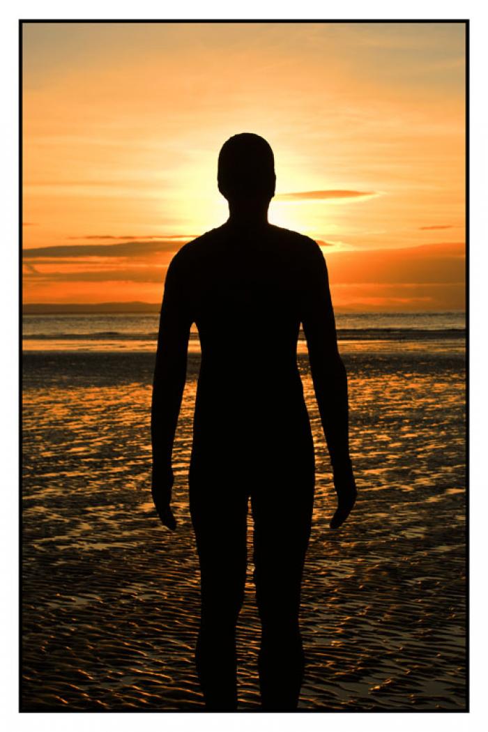 Statue silhouetted against the setting sun, Another Place, Crosby Beach